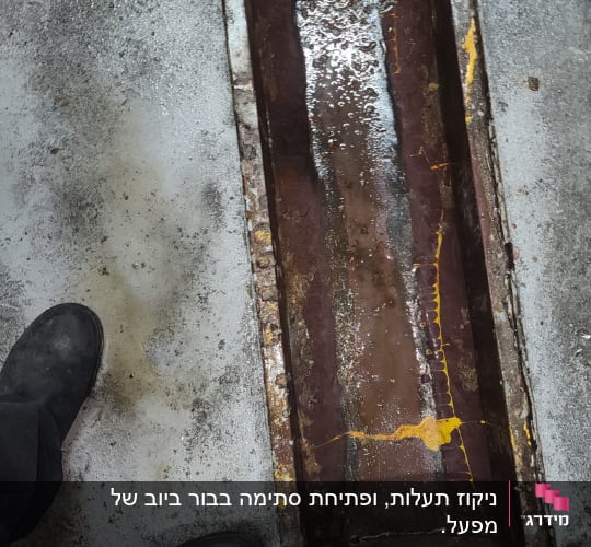 תעלת ניקוז פתוחה עם מים על רצפת בטון
